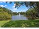 Picturesque pond with a fountain, framed by lush greenery and trees against a backdrop of blue sky and scattered clouds at 2124 Wisteria St, Sarasota, FL 34239
