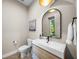 Stylish powder room featuring a modern vanity, elegant mirror, and neutral color palette, with view to exterior at 2124 Wisteria St, Sarasota, FL 34239