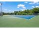 A sprawling tennis court complex features multiple courts with blue playing surfaces and green surroundings under a sunny sky at 2124 Wisteria St, Sarasota, FL 34239