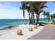 Picturesque waterfront path lined with palm trees, decorative spheres and stunning water views at 2124 Wisteria St, Sarasota, FL 34239