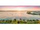 Picturesque waterfront view showcasing a tranquil bay with numerous boats, framed by lush trees and a vibrant sunset at 2124 Wisteria St, Sarasota, FL 34239