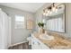 Modern bathroom with granite countertop, decorative mirror, and modern lighting fixture at 217 Giotto Dr, Nokomis, FL 34275