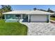 Charming teal home featuring a spacious two-car garage, tile roof, and beautifully paved driveway at 217 Giotto Dr, Nokomis, FL 34275