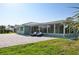 Rear exterior of home with large brick patio, lounge chairs, and ample green space at 217 Giotto Dr, Nokomis, FL 34275
