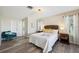 Bright main bedroom with wood-look floors, neutral decor, and a cozy accent chair at 217 Giotto Dr, Nokomis, FL 34275