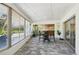 Bright and airy enclosed patio with stone floors, white walls and ceiling, large windows, and seating area at 217 Giotto Dr, Nokomis, FL 34275