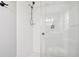 All-white tiled shower with glass enclosure and modern fixtures at 217 Giotto Dr, Nokomis, FL 34275