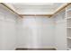 Spacious walk-in closet featuring wood rods for hanging and built in storage shelves at 217 Giotto Dr, Nokomis, FL 34275