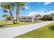 Attractive home with a long driveway, featuring lush green lawn and tropical palm trees at 219 Marlin Dr, Punta Gorda, FL 33950