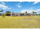 Inviting single-story home with a lush green lawn, large windows, and tropical palm trees at 219 Marlin Dr, Punta Gorda, FL 33950