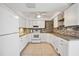 Spacious kitchen boasts white appliances, cabinets, neutral countertops, and a brick backsplash at 219 Marlin Dr, Punta Gorda, FL 33950