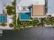 Aerial view of a home with a stunning pool, outdoor lounge area, a green putting range, and lush tropical landscaping at 224 Chilson Ave, Anna Maria, FL 34216