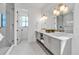 Elegant bathroom featuring a double vanity, marble countertops, and a glass-enclosed shower at 224 Chilson Ave, Anna Maria, FL 34216