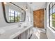 Bathroom featuring a large mirror, white marble countertops, grey vanity, and glass enclosed shower with decorative tile at 224 Chilson Ave, Anna Maria, FL 34216