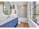 Charming bathroom with blue vanity, white marble counters, decorative lights, and lovely decorative shower backsplash at 224 Chilson Ave, Anna Maria, FL 34216
