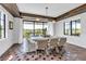 Stylish dining area featuring dark wood beam accents and natural light from windows and sliding door at 224 Chilson Ave, Anna Maria, FL 34216