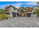 Stunning exterior of a two-story home featuring a spacious driveway and tropical landscaping at 224 Chilson Ave, Anna Maria, FL 34216