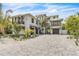 Stunning two-story home featuring lush tropical landscaping and a beautiful paved driveway at 224 Chilson Ave, Anna Maria, FL 34216