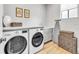 Well-lit laundry room featuring front loading washer and dryer, white countertops, and wood-look floors at 224 Chilson Ave, Anna Maria, FL 34216