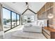 Bright main bedroom with vaulted ceilings, a ceiling fan, a wood accent wall, and a sliding door to a balcony at 224 Chilson Ave, Anna Maria, FL 34216