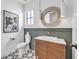 Chic powder room with a wooden vanity, decorative mirror, and patterned tile flooring at 224 Chilson Ave, Anna Maria, FL 34216