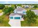 Aerial view of a two story home with a three car garage and manicured lawn at 25364 Tether Ln, Punta Gorda, FL 33983
