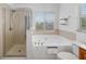 Bright bathroom with tile floors, a soaking tub, and a glass door shower at 25364 Tether Ln, Punta Gorda, FL 33983