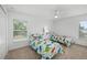 Bright bedroom with dinosaur themed bedding, a ceiling fan, and a large window at 25364 Tether Ln, Punta Gorda, FL 33983