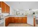Bright kitchen with wood cabinets, light countertops and tile flooring overlooking a living area at 25364 Tether Ln, Punta Gorda, FL 33983
