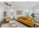 Bright living room with modern decor, wood floors, ceiling fan, and an abundance of natural light at 25364 Tether Ln, Punta Gorda, FL 33983