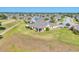 Panoramic aerial view highlighting the property, its screened lanai, expansive yard, and community surroundings at 302 Crystal Downs Ct, Sun City Center, FL 33573