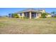 Home's backyard featuring a screened lanai, well-maintained lawn, and partial view of the surrounding community at 302 Crystal Downs Ct, Sun City Center, FL 33573