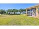 Expansive backyard with lush grass, mature trees, and views of the serene lake, perfect for outdoor enjoyment at 302 Crystal Downs Ct, Sun City Center, FL 33573