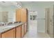 Bathroom with double vanity with granite counters and glass-enclosed shower at 302 Crystal Downs Ct, Sun City Center, FL 33573