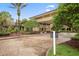 Elegant building entrance with tropical landscaping and brick-paved walkway at 302 Crystal Downs Ct, Sun City Center, FL 33573