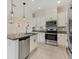 Well-lit kitchen boasts stainless steel appliances, granite countertops, and sleek cabinets with tile floor at 302 Crystal Downs Ct, Sun City Center, FL 33573