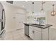 Stylish kitchen island with stainless steel dishwasher, white cabinets, and tile flooring at 302 Crystal Downs Ct, Sun City Center, FL 33573