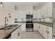 Modern kitchen features granite countertops, stainless steel appliances, and crisp white cabinets at 302 Crystal Downs Ct, Sun City Center, FL 33573