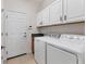 Bright laundry room featuring modern washer and dryer, granite countertop, and ample storage cabinets at 302 Crystal Downs Ct, Sun City Center, FL 33573