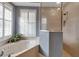 Bright bathroom features a soaking tub and shower with natural light streaming through shuttered windows at 3738 Eagle Hammock Dr, Sarasota, FL 34240