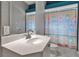 Bright bathroom featuring a sink with a mirror and a shower with colorful curtains, creating a clean and inviting atmosphere at 3738 Eagle Hammock Dr, Sarasota, FL 34240