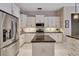 Well-lit kitchen with stainless steel refrigerator, island, granite counters, and white cabinetry at 3738 Eagle Hammock Dr, Sarasota, FL 34240