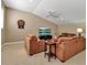 Comfortable living room with plush armchairs, sofa, television, ceiling fan, and guitar at 3738 Eagle Hammock Dr, Sarasota, FL 34240