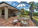Screened-in brick patio with outdoor table, chairs, grill, and view of the yard at 3738 Eagle Hammock Dr, Sarasota, FL 34240