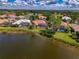 Aerial view of a charming neighborhood with homes bordering a serene lake and beautiful greenery at 410 Wellington, Venice, FL 34292