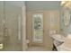 Bright bathroom featuring tiled shower, wood paneling, and modern fixtures at 410 Wellington, Venice, FL 34292