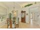 Elegant dining room with a glass-top table, a chandelier, and natural light streaming through the window at 410 Wellington, Venice, FL 34292
