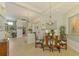 Open-concept dining area with a glass table, a chandelier, and views into the living space at 410 Wellington, Venice, FL 34292