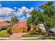 Well-maintained home with a red tile roof, a two-car garage, and vibrant, mature landscaping at 410 Wellington, Venice, FL 34292