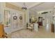Bright foyer featuring elegant glass double doors, tile flooring, and a view to the dining area at 410 Wellington, Venice, FL 34292